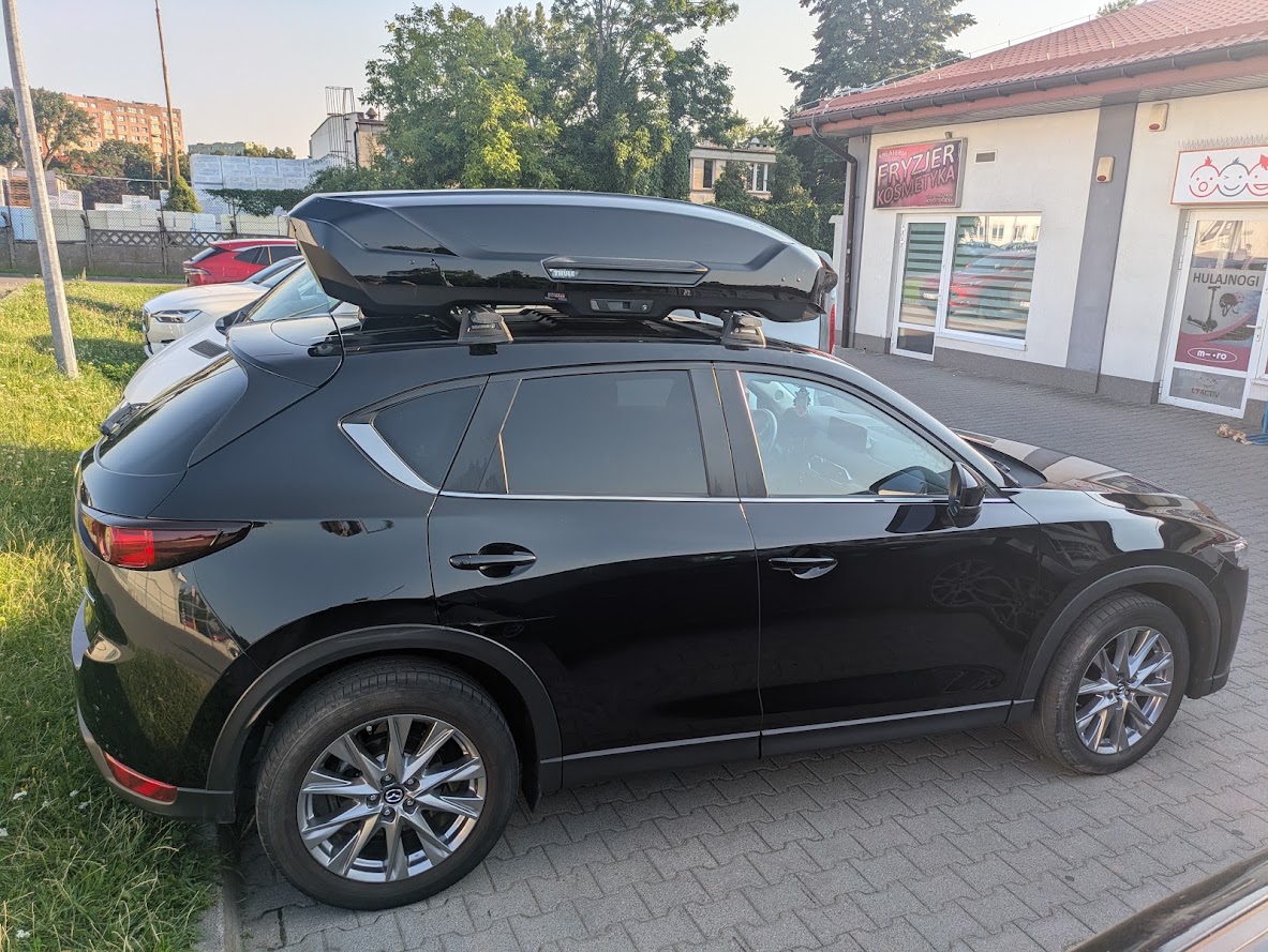 Prawy bok Mazdy CX-5 z boxem Thule Motion 3 L na belkach Yakima